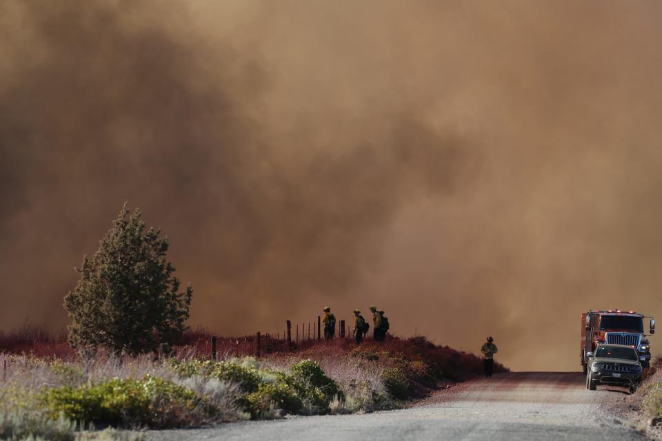 Cal Fire firefighters stand guard along a road on Friday, Sept. 2, 2022 near Lake Shastina Subdivision northwest of Weed, California. The Mill Fire erupted that afternoon in the area of the Roseburg Forest Products mill in Weed and raced out of control, forcing residents in that Northern California community, Lake Shastina and Edgewood to flee their homes.