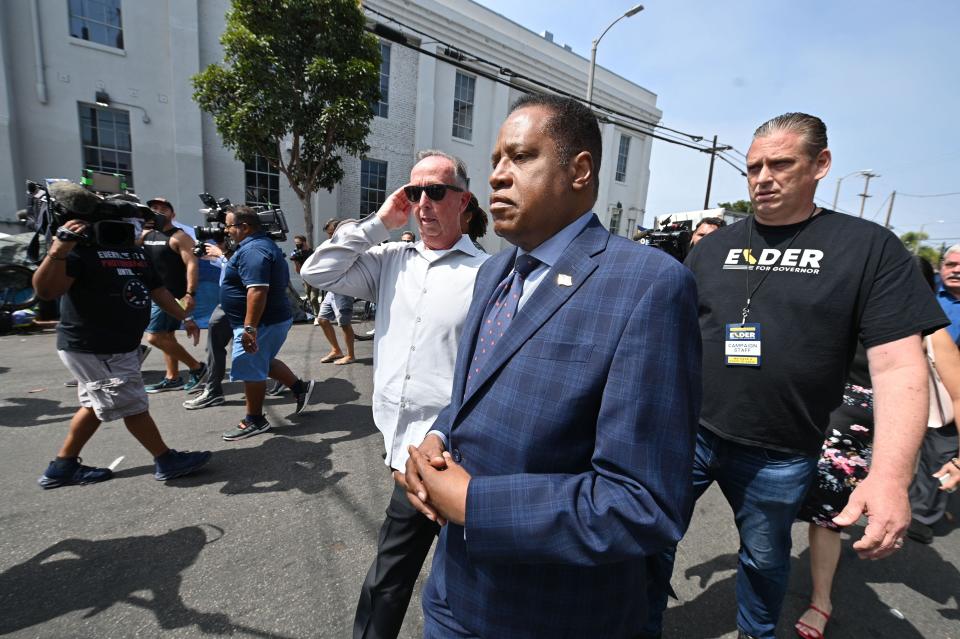 Conservative talk show host and gubernatorial recall candidate Larry Elder (C) walks along streets lined with tents of unhoused people, in the Venice neighborhood of  Los Angeles, California, 8 September 2021. (AFP via Getty Images)