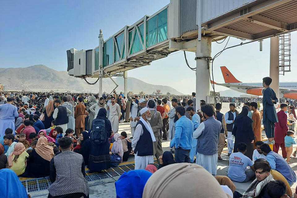 Afghans crowd at the tarmac of the Kabul airport on August 16, 2021, to flee the country as the Taliban were in control of Afghanistan after President Ashraf Ghani fled the country and conceded the insurgents had won the 20-year war. / Credit: AFP via Getty Images