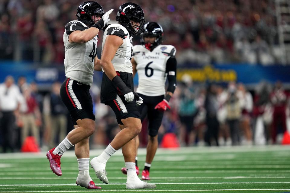 Cincinnati Bearcats linebacker Darrian Beavers (0) is congratulated by Cincinnati Bearcats linebacker Joel Dublanko (41) after a tackle of Alabama Crimson Tide running back Brian Robinson Jr. (4) for a loss in the first quarter during the College Football Playoff semifinal game at the 86th Cotton Bowl Classic, Friday, Dec. 31, 2021, at AT&T Stadium in Arlington, Texas.