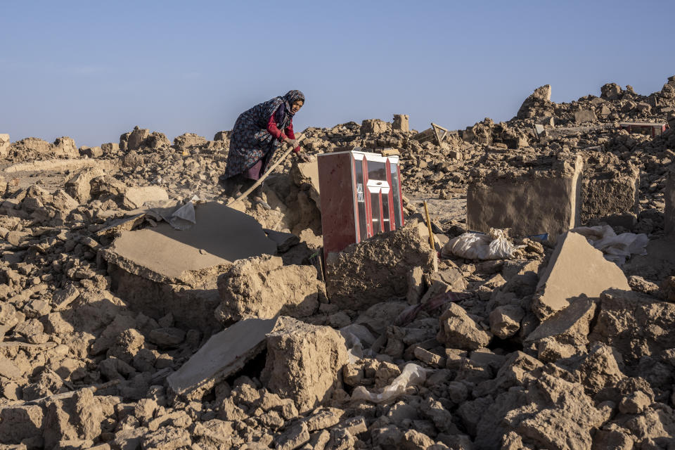 A woman cleans up rubble after an earthquake in Zenda Jan district in Herat province, western Afghanistan, Wednesday, Oct. 11, 2023. Another strong earthquake shook western Afghanistan on Wednesday morning after an earlier one killed more than 2,000 people and flattened whole villages in Herat province in what was one of the most destructive quakes in the country's recent history. (AP Photo/Ebrahim Noroozi)