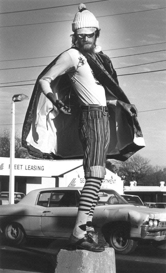 Dressed for Christmas, Carl Hickerson spins a carnation on its stem on the end of his finger while gyrating on a concrete block at North Lamar Boulevard and West Sixth Street in this undated photo.