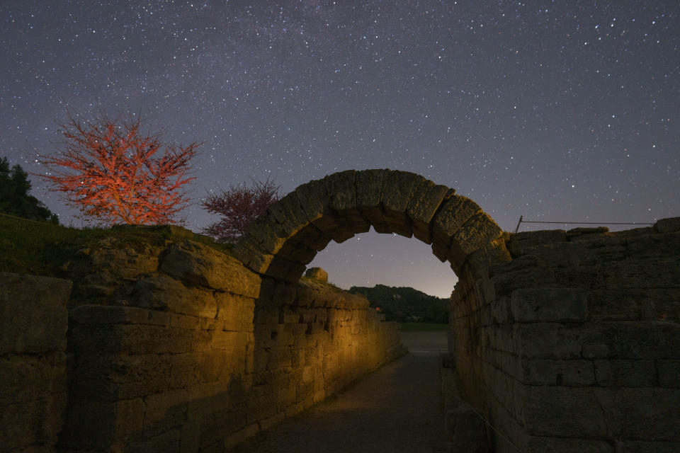 The 3rd century B.C. stone arch leading into the ancient stadium of Olympia, birthplace of the Olympic Games, is seen under the stars, early Tuesday, April 9, 2024, in a night-time image made following special permission by the Culture Ministry. The ancient Olympic Games began in 776 BC. Only the athletes and the officials were allowed to use this entrance. (AP Photo/Petros Giannakouris)