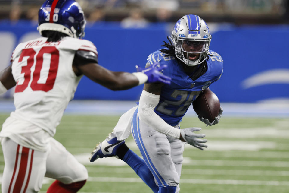 Detroit Lions running back Jahmyr Gibbs (26) rushes as New York Giants cornerback Darnay Holmes (30) defends during the first half of an NFL preseason football game, Friday, Aug. 11, 2023, in Detroit. (AP Photo/Duane Burleson)