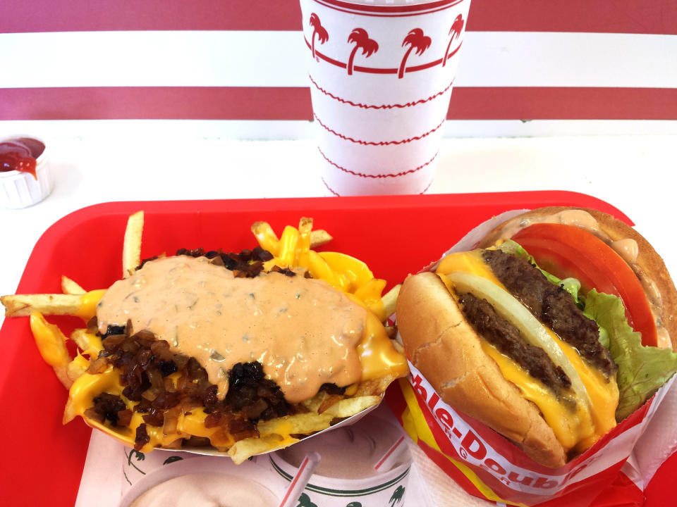 Animal Style fries and In-N-Out burger with a soda