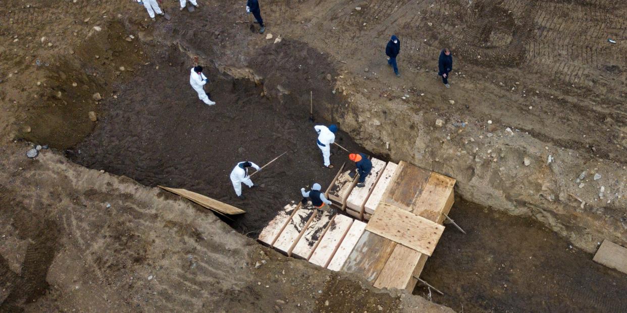 coronavirus covid 19 burial trenches inmates burying unclaimed bodies wooden caskets hart island potters field new york city cemetery nyc bronx april 9 2020 04 09T164235Z_1389564795_RC241G91KIPT_RTRMADP_3_HEALTH CORONAVIRUS USA HART ISLAND.JPG