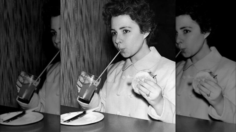 woman enjoying burger and drink 