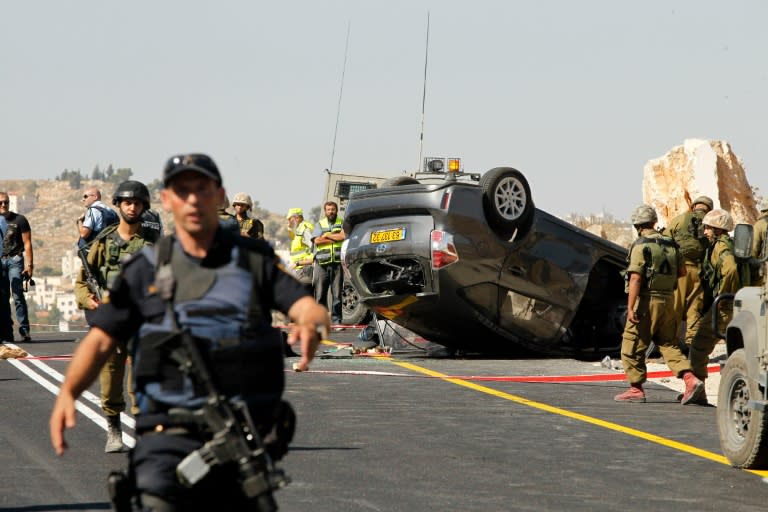 Israeli security forces and emergency personnel gather at the scene where an Israeli was killed and three of his relatives were wounded after a suspected Palestinian gunman opened fire at their car on July 1, 2016, south of Hebron