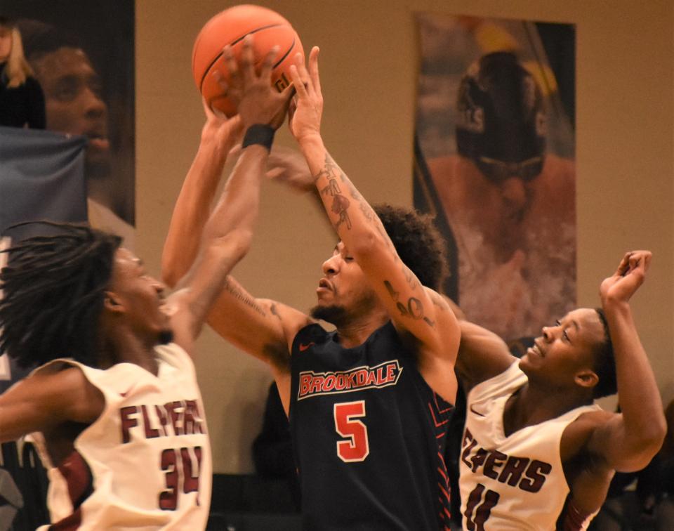 Brookdale Community College's Niles Halliburton (5) attempts a shot between Sandhills Community College Flyers Bryan Quiller and HIedan Coleman (from left) during the first half of the NJCAA Division III men's basketball championship game Saturday at Herkimer College.