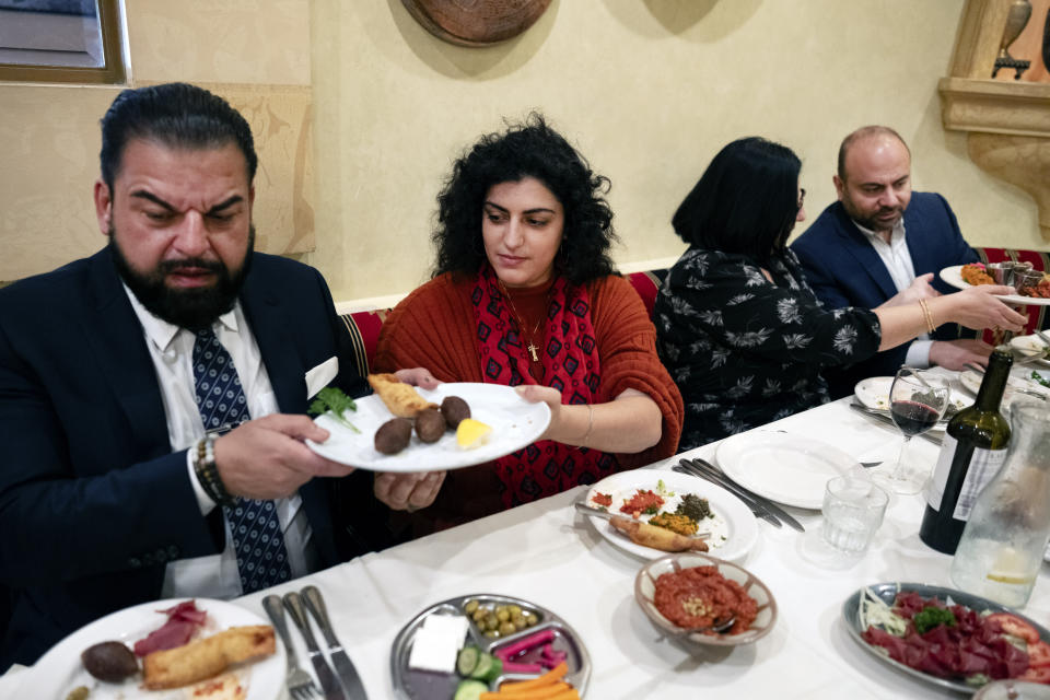 Sophia Armen, center passes a dish to Dr. Armond Aghakhanian and joined for lunch with other members of the Armenian-American Census Coalition, Suzie Abajian and former California Assembly Member Adrian Nazarian at the Carousel, a Lebanese-Armenian restaurant in Glendale, Calif. on Friday, May 17, 2024. For some race and ethnic groups, how the U.S. government categorizes them for crucial surveys and the once-a-decade census is still falling short. Hmong as well as Armenian, Arab American and Brazilian communities say they feel excluded or diminished when it comes to how they are counted in their own country. (AP Photo/Richard Vogel)