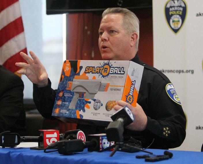 Akron Police Department Chief Stephen Mylett shows off a box containing a SplatRBall toy gun during a press conference Wednesday at the police department.