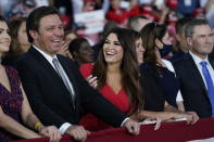 Florida Gov. Ron DeSantis smiles next to Kimberly Guilfoyle as President Donald Trump speaks during a campaign rally at Orlando Sanford International Airport, Monday, Oct. 12, 2020, in Sanford, Fla. (AP Photo/Evan Vucci)