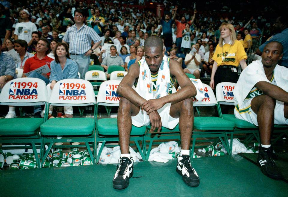 FILE - In this May 7, 1994,   dejected Gary Payton, center, of the Seattle SuperSonics sits on the bench during the final moments of a playoff game against the Denver Nuggets in Seattle. With the retirement of Michael Jordan prior to the 1993-1994 season, the Sonics were thought by many as a favorite to win the NBA Championship. But, in the first round of the Western Conference playoffs, the Sonics lost the series 2-3 to the Nuggets.  (AP Photo/Gary Stewart, File