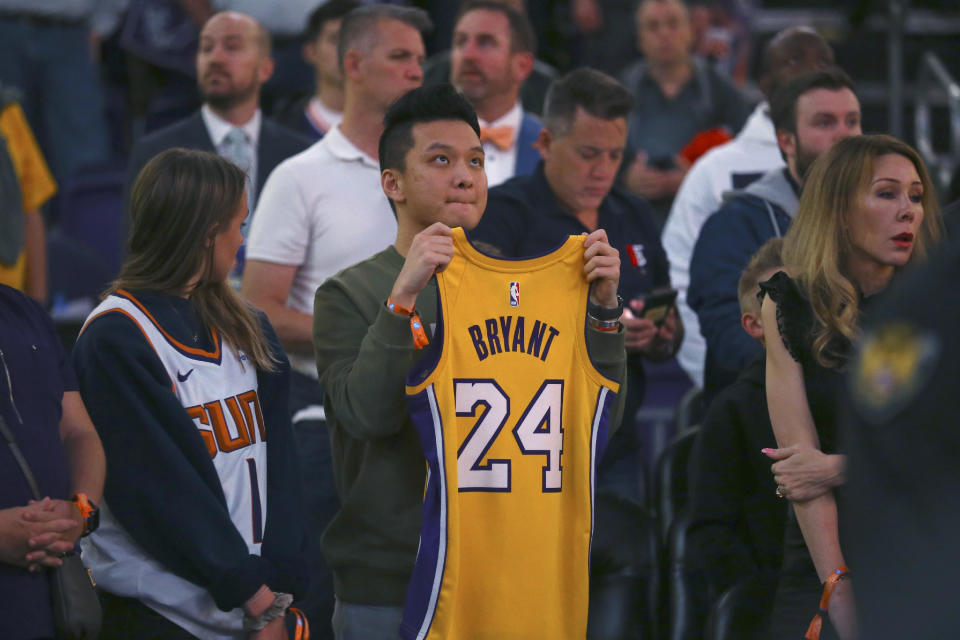 Fans pause during 24 seconds of silence in memory of Los Angeles Lakers' Kobe Bryant and all those killed in a helicopter crash last Sunday, prior to an NBA basketball game between the Phoenix Suns and the Oklahoma City Thunder on Friday, Jan. 31, 2020, in Phoenix. (AP Photo/Ross D. Franklin)