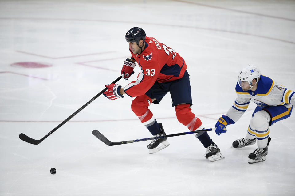 Washington Capitals defenseman Zdeno Chara (33) chases the puck past Buffalo Sabres left wing Taylor Hall (4) during the first period of an NHL hockey game, Friday, Jan. 22, 2021, in Washington. (AP Photo/Nick Wass)