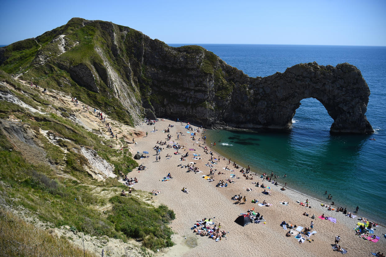 People enjoy the warm weather on the beach at Durdle Door, near Lulworth, in Dorset, after the public were reminded to practice social distancing following the relaxation of lockdown restrictions in England.