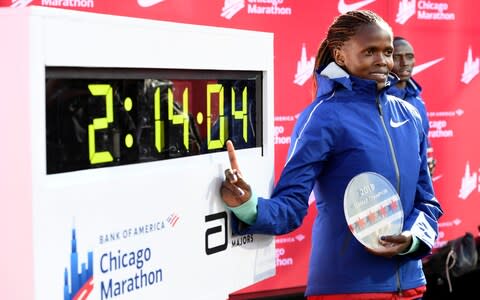 Kenya's Brigid Kosgei stands next to her world-record time - Credit: ap