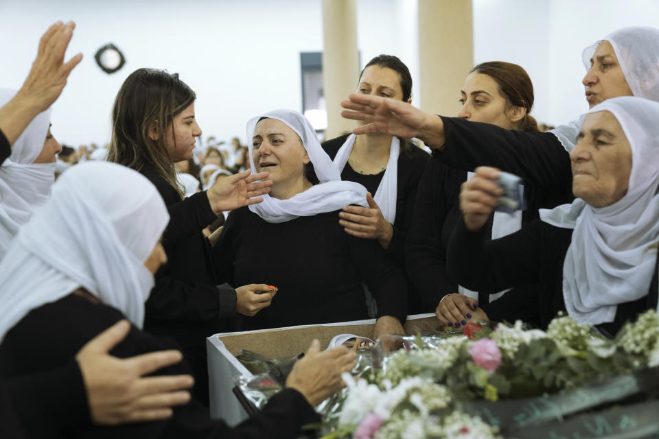 Members of the Israeli Druze minority mourn around the body of Tiran Fero, 17, during his funeral in Daliyat al-Carmel, Israel, Thursday, Nov. 24, 2022. Fero's body, which was taken by Palestinian militants on Wednesday from a West Bank hospital where he was seeking treatment after a car accident, was returned to his family on Thursday. (AP Photo/Mahmoud Illean)