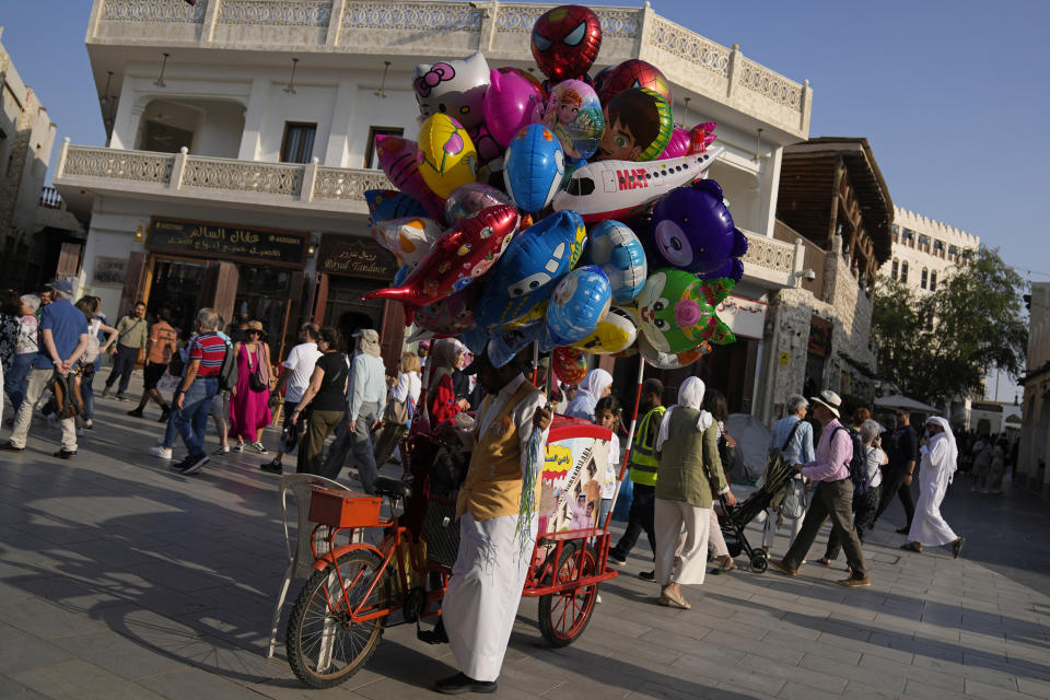 A migrant worker sells decorative balloons on a cart at Souk Waqif in Doha, Qatar, Tuesday, Jan. 16, 2024. The plight of migrant workers in Qatar came under the spotlight for more than decade after the gas-rich Middle Eastern emirate was awarded the World Cup in 2010. Workers labored in the searing heat to build over $200 billion worth of stadiums and infrastructure that helped make the tournament such a success. (AP Photo/Aijaz Rahi)