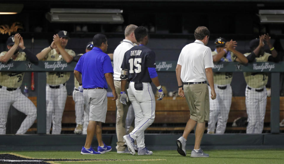 Duke's Kennie Taylor (15) leaves the field after being hit in the face by a pitch, as Vanderbilt payers applaud during the first inning of an NCAA college baseball tournament super regional game Saturday, June 8, 2019, in Nashville, Tenn. (AP Photo/Wade Payne)