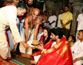 Indian actors Abhishek Bachchan (2R) and Aishwarya Rai (C/R) are watched by Amitabh Bachchan (C) and industrialist Anil Ambani (R) as they take prasad (blessed food) from priests during a visit to The Lord Venkatesh Wara Temple at Tirupati,some 550 kms south of Hyderabad,22 April 2007. Bollywood stars Aishwarya Rai and Abhishek Bachchan began life as "Mr and Mrs Bachchan" 21 April, after three days of wedding celebrations for Indian cinema's ultimate power couple. AFP PHOTO/NOAH SEELAM
