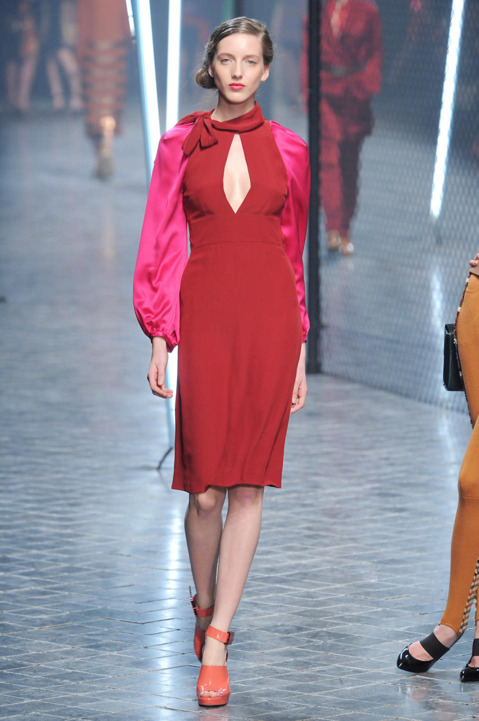 A model walks the runway in a red dress with fuchsia sleeves at the fall 2011 Sonia Rykiel fashion show in Paris.