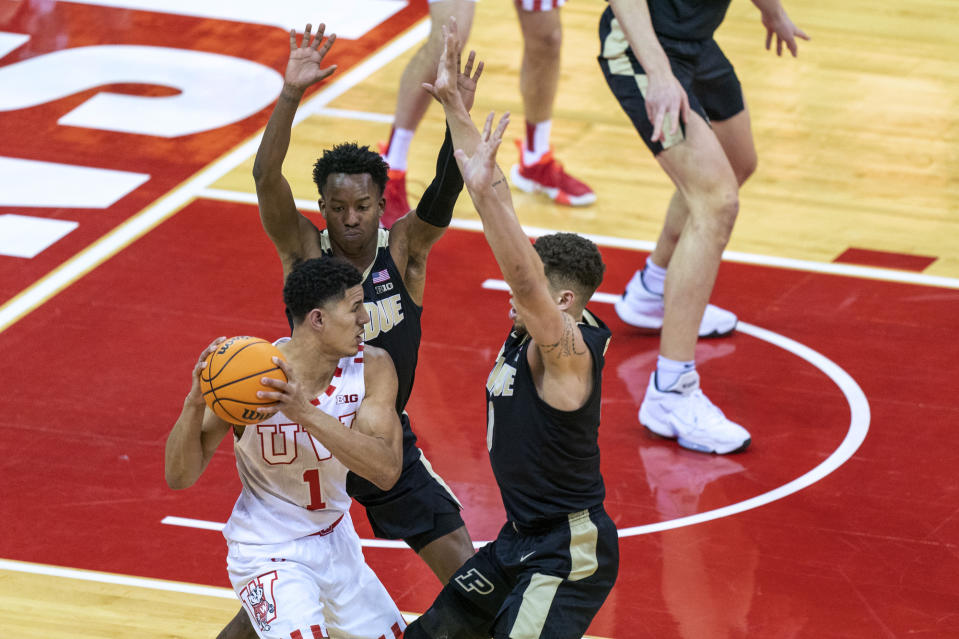 Wisconsin's Johnny Davis (1) is guarded by Purdue's Eric Hunter, behind, and Mason Gillis during the first half of an NCAA college basketball game Tuesday, March 1, 2022, in Madison, Wis. (AP Photo/Andy Manis)
