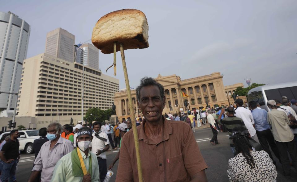 A supporter of Sri Lanka's main opposition displays a loaf of bread to highlight the rising food prices during a protest outside the president's office in Colombo, Sri Lanka, Tuesday, March 15, 2022. The protestors were demanding the resignation of President Gotabaya Rajapaksa as the country suffers one of the worst economic crises in history. (AP Photo/Eranga Jayawardena)