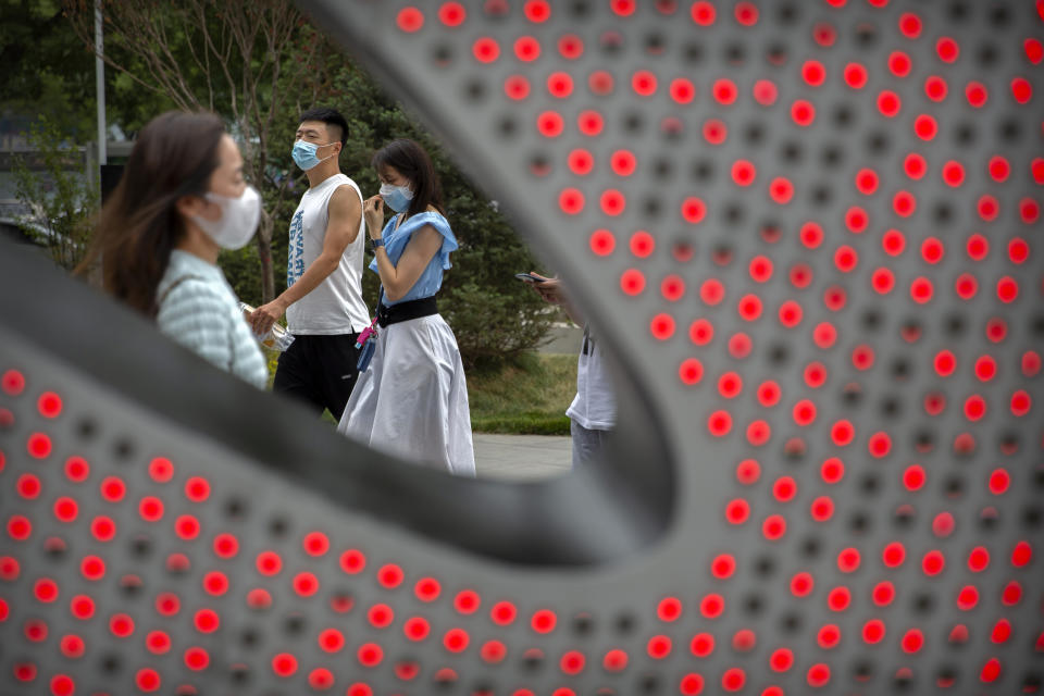 People wearing face masks to protect against the spread of the new coronavirus walk through a shopping and office complex in Beijing, Wednesday, June 24, 2020. New virus cases have declined in China and in the capital Beijing, where a two-week spike appears to be firmly waning. (AP Photo/Mark Schiefelbein)