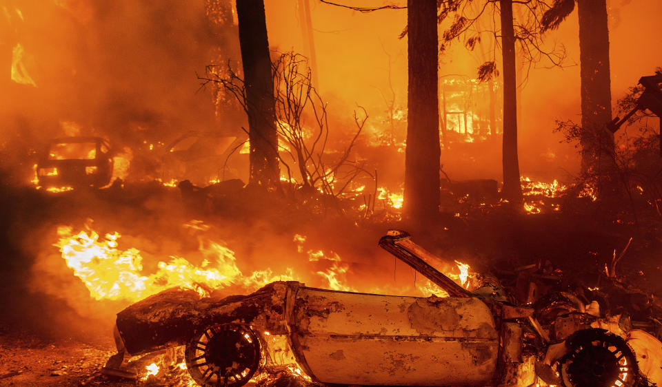 Flames consume vehicles as the Dixie Fire tears through the Indian Falls community in Plumas County, Calif., Saturday, July 24, 2021. The fire destroyed multiple residences in the area. (AP Photo/Noah Berger)