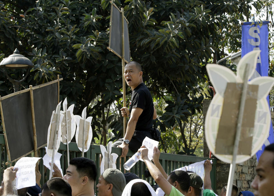 In this Feb. 20, 2014 photo, Roman Catholic priest Father Robert Reyes sits on the gates of the National Housing Authority after jogging with supporters to protest the demolition of an informal settlers community that will pave the way for the construction of shopping malls in Quezon city northeast of Manila, Philippines. For more than 30 years, Reyes, dubbed the “running priest” by the local media, has been a constant critic of corruption in the Philippines and often times the church itself, which he charges has abandoned its obligation to help the poor and sided with those in power in Asia’s largest Roman Catholic nation. (AP Photo/Bullit Marquez)