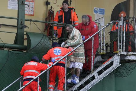 A wounded passenger is helped as he leaves from the " Spirit of Piraeus " cargo container ship after the car ferry Norman Atlantic caught fire in waters off Greece December 29, 2014. REUTERS/Stringer