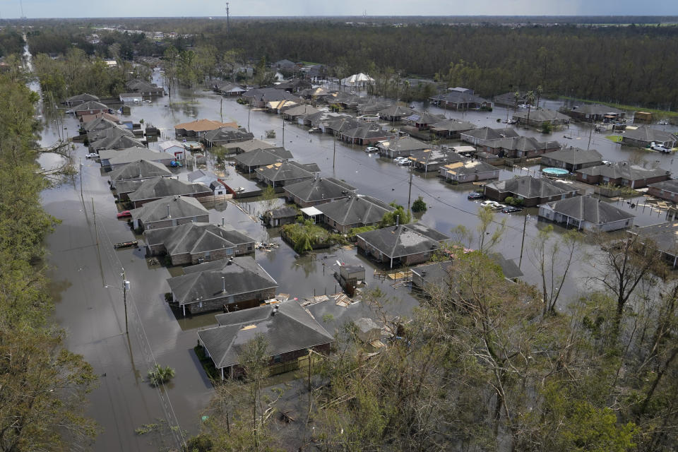 FILE - Homes are flooded in the aftermath of Hurricane Ida in LaPlace, La., Tuesday, Aug. 31, 2021. Wildfires, floods and soaring temperatures have made climate change real to many Americans. Yet a sizeable number continue to dismiss the scientific consensus that human activity is to blame. That's in part because of a decades-long campaign by fossil fuel companies to muddy the facts and promote fringe explanations. (AP Photo/Gerald Herbert, File)
