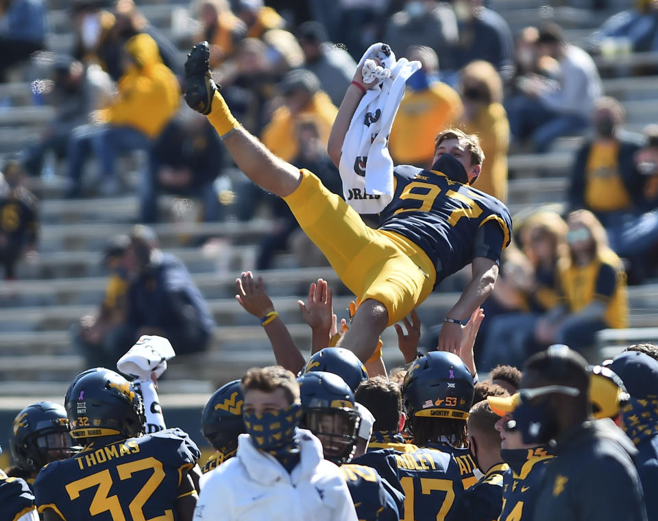 West Virginia players toss place kicker Danny King (97) into the air after a score against Kansas during an NCAA college football game Saturday, Oct. 17, 2020, in Morgantown, W.Va. (William Wotring/The Dominion-Post via AP)