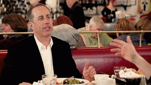 Jerry Seinfeld looks surprised at a check at a restaurant