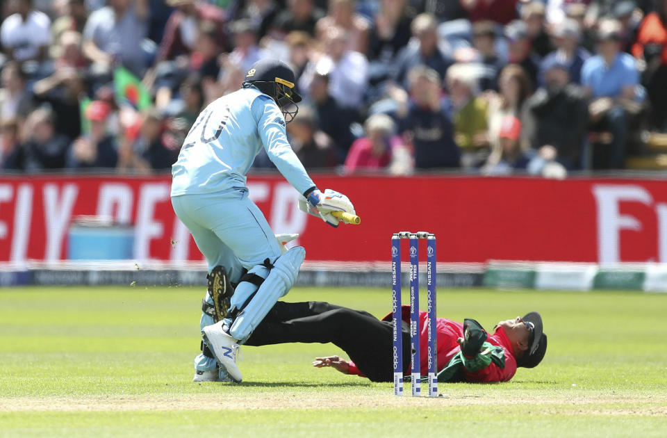 England's Jason Roy collides with the umpire Joel Wilson after hitting his century during the ICC Cricket World Cup group stage match between England and Bangladesh at the Cardiff Wales Stadium, Wales, Saturday, June 8, 2019. (David Davies/PA via AP)