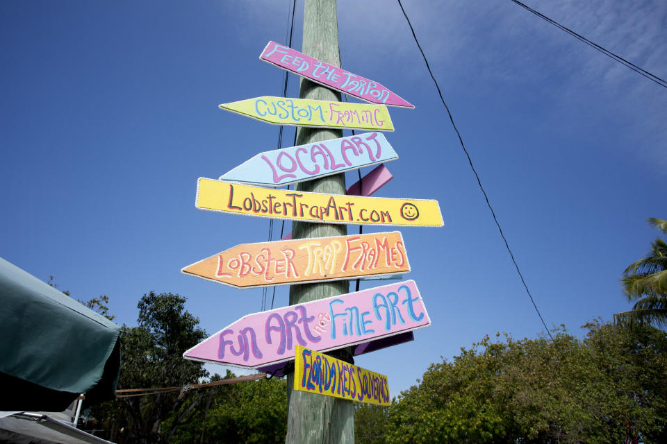 In this Feb. 12, 2013 photo, signs for art galleries are shown in Lower Matecumbe Key, Fla. For a bit of subtropical paradise, travelers can head to the Keys to enjoy every water activity imaginable _ from sailing to sport fishing. The Florida Keys, spanning over 100 miles connected by bridges and causeways, offer plenty of activities at no cost. (AP Photo/J Pat Carter)