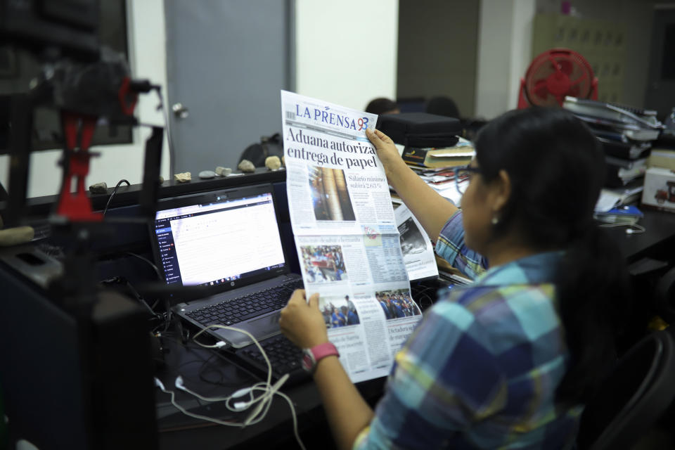 A journalist holds up a copy of La Prensa independent newspaper with a headline that reads in Spanish; "Customs authorizes release of printing paper," in Managua, Nicaragua, Friday, Feb. 7, 2020. La Prensa had announced Wednesday that the government had agreed to unblock the newspaper's printing materials held up since August 2018. It said the Vatican's top diplomat in Managua, Waldemar Stanislaw Sommertag, had intervened on its behalf. (AP Photo/Alfredo Zuniga)