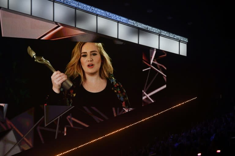 A big screen shows British singer-songwriter Adele accepting the BRITs global success award during the BRIT Awards 2017 ceremony and live show in London on February 22, 2017