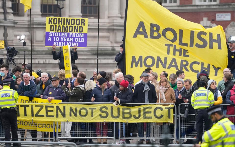 Anti-monarchy protesters hold up banners and placards as they demonstrate outside Westminster Abbey