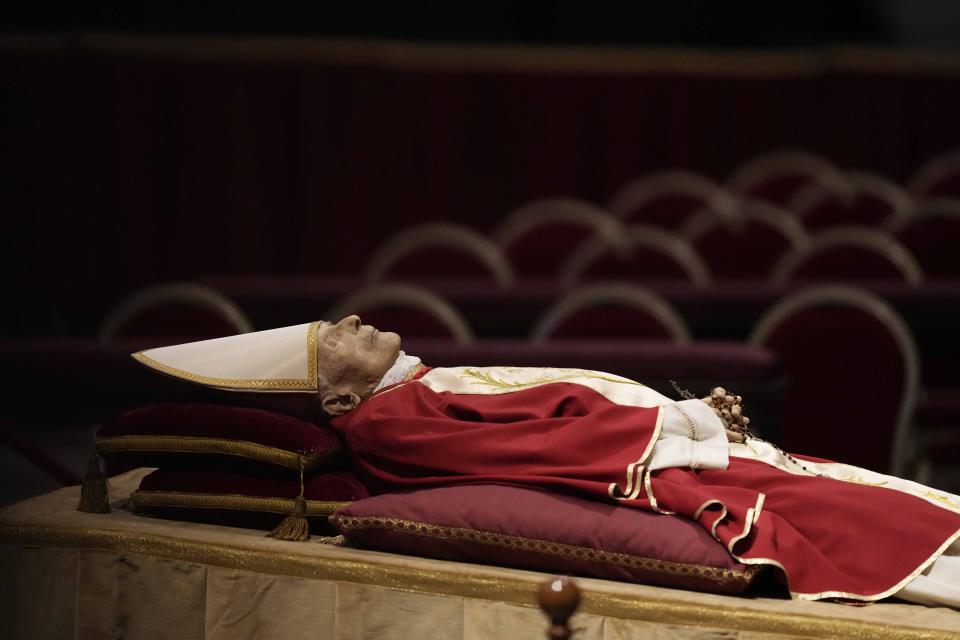 The body of late Pope Emeritus Benedict XVI laid out in state inside St. Peter's Basilica at The Vatican, Monday, Jan. 2, 2023. (AP Photo/Andrew Medichini)