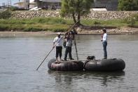 A television journalist speaks to the camera on a raft along the Suchiate river, after the arrival of the women from the "Caravana de Madres Centroamericanas" (Caravan of Central American Mothers) to the border city of Tecun Uman, north of Guatemala, December 18, 2013. According to the organizers, the group which is made up of relatives of people who went missing while making their way to the U.S. went to Mexico in the last two weeks to demand that the governments of Mexico and Central America stop the kidnappings and crimes committed by organised criminal groups against migrants. REUTERS/Jorge Dan Lopez (GUATEMALA - Tags: CRIME LAW SOCIETY IMMIGRATION MEDIA)