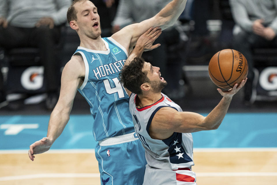 Washington Wizards guard Raul Neto, right, drives to the basket while guarded by Charlotte Hornets center Cody Zeller (40) during the first half of an NBA basketball game in Charlotte, N.C., Sunday, Feb. 7, 2021. (AP Photo/Jacob Kupferman)