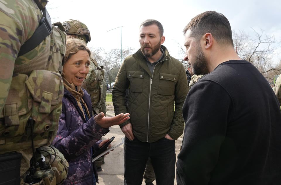 El presidente de Ucrania, Volodymyr Zelenskyy, habla con Julie Pace, vicepresidenta sénior y directora editorial de The Associated Press, durante una visita a una zona dañada por misiles rusos en Zaporiyia, Ucrania, el lunes 27 de marzo de 2023. (AP Foto/Efrem Lukatsky)