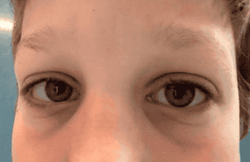 Close-up of a person's eyes looking directly at the camera, eyebrows slightly raised