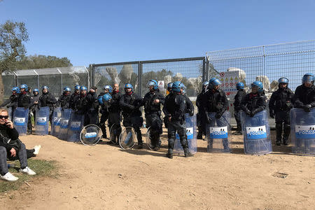 Italian riot police stand in front of a grove of olive trees dating back centuries in the village of Melendugno, southern Italy March 28, 2017. REUTERS/Stringer