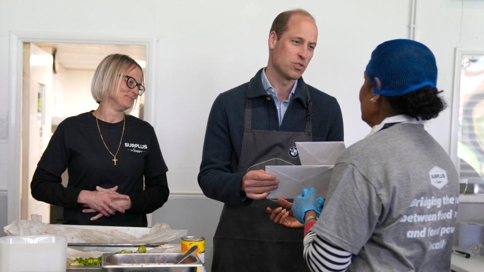 Prince William, Prince of Wales is given cards for his wife Catherine, Princess of Wales by volunteer Rachel Candappa