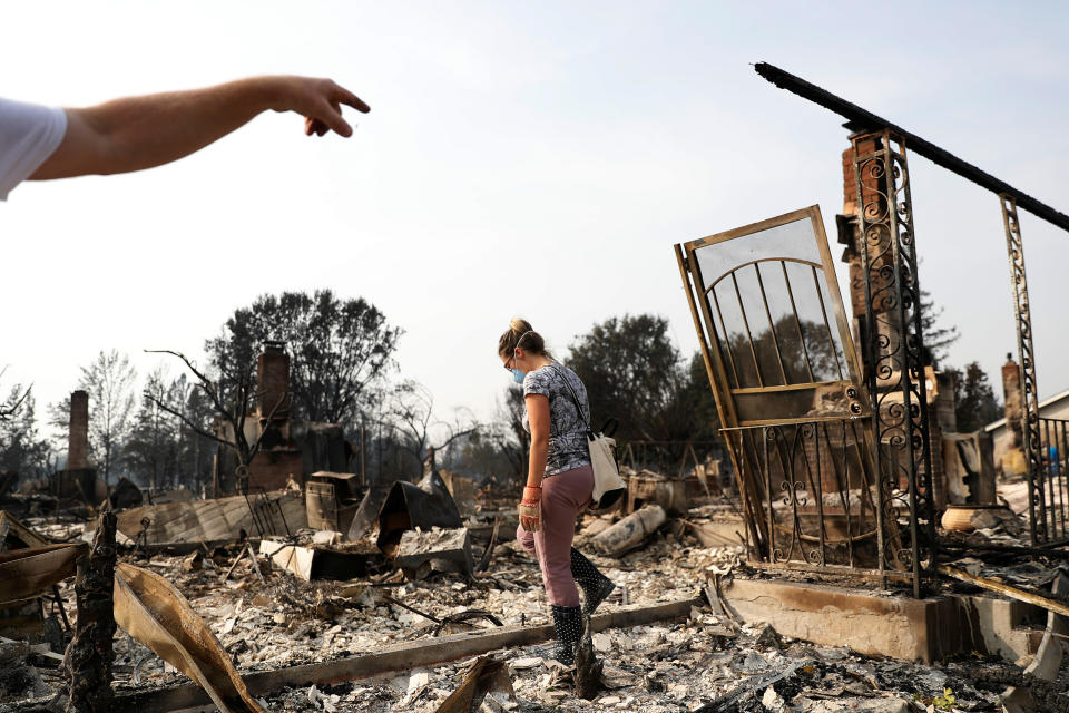 <p>Harper Bishop (L) points to a section of his home as wife Cristy surveys their home destroyed by the Tubbs Fire in Santa Rosa, Calif., Oct. 10, 2017. (Photo: Stephen Lam/Reuters) </p>