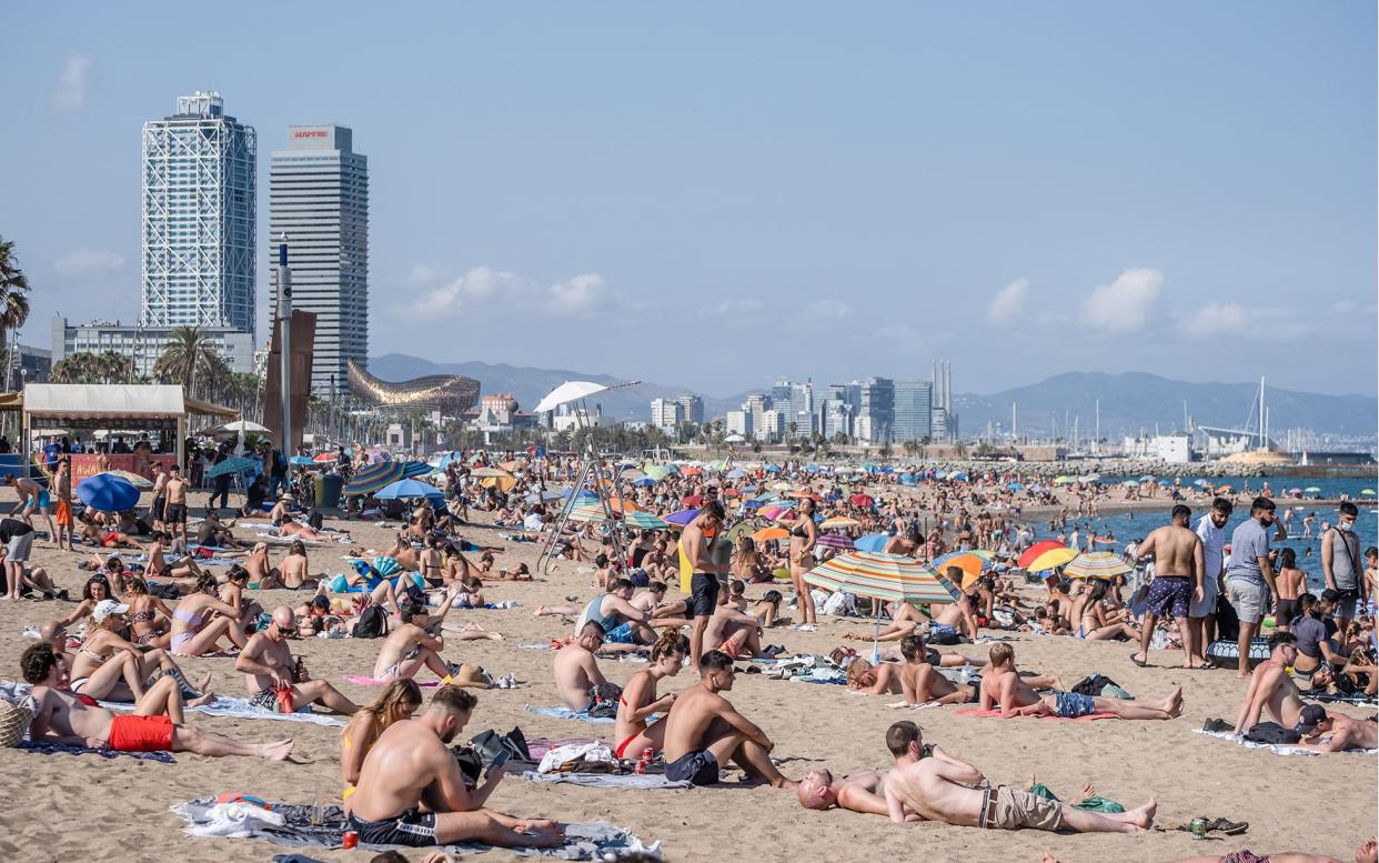 People enjoy the sunny weather at the Barceloneta beach - Getty