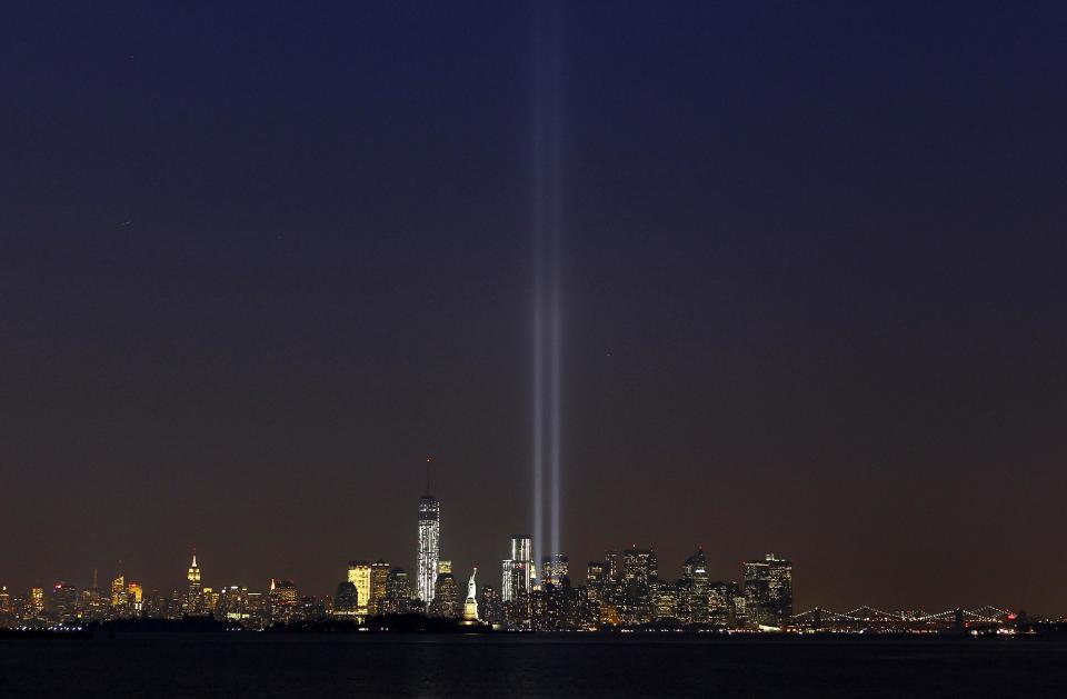 The Tribute in Light is illuminated next to the Statue of Liberty (C) and One World Trade Center (L) during events marking the 12th anniversary of the 9/11 attacks on the World Trade Center in New York, September 10, 2013. (REUTERS/Gary Hershorn)